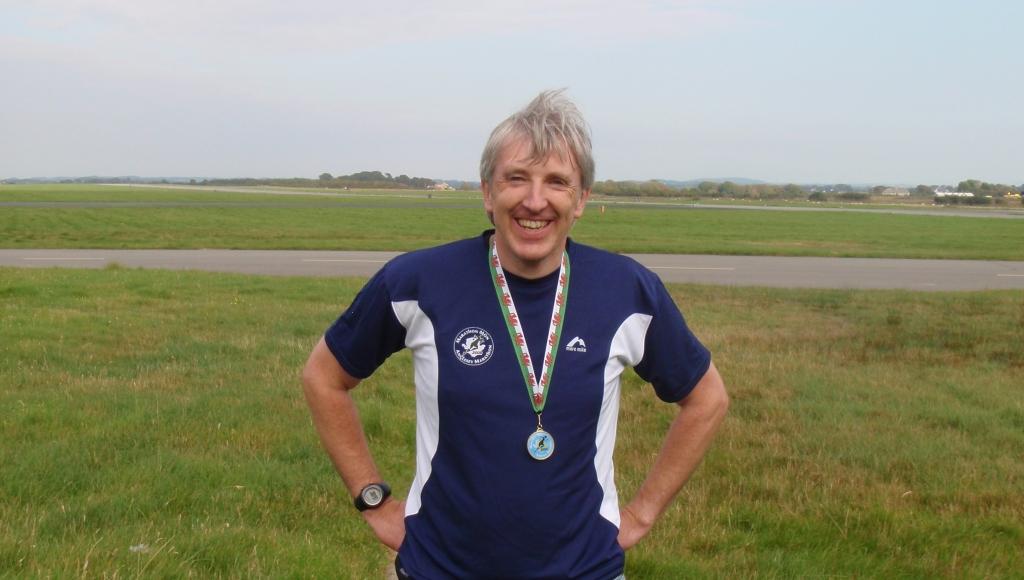 I'm not smiling - I'm grimacing in pain! Post-race with my hard-earned medal. Not much for all that effort.